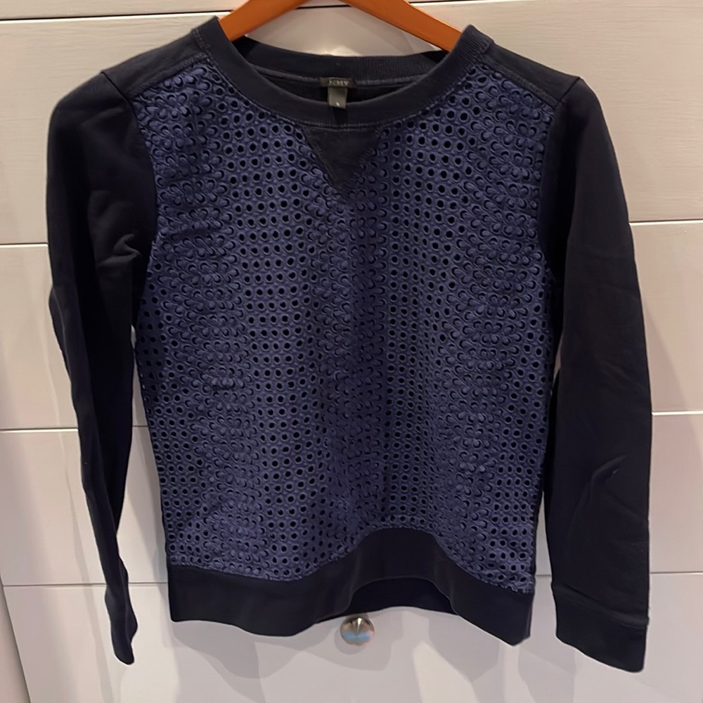 J.Crew navy sweatshirt with lace like cutouts on the front.